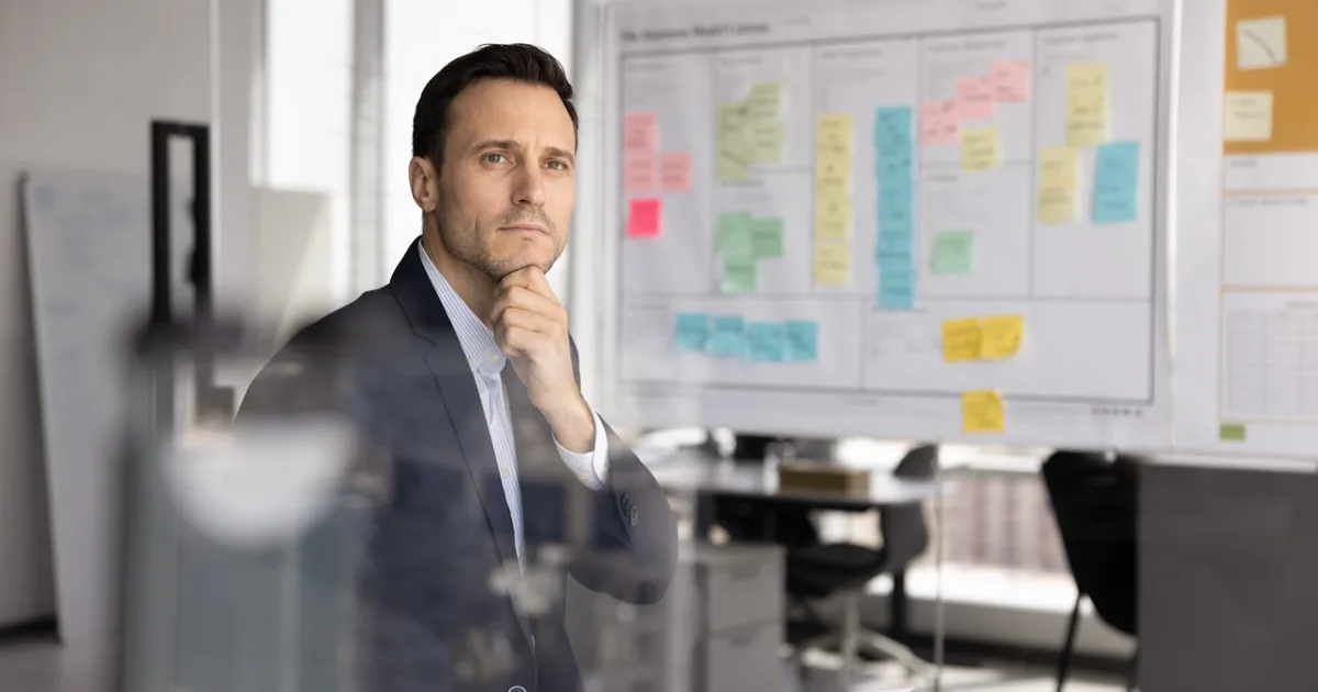 Manager reviewing a strategy board in a bright office.