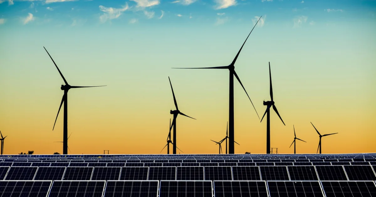 Solar panels and wind turbines in a renewable energy array.