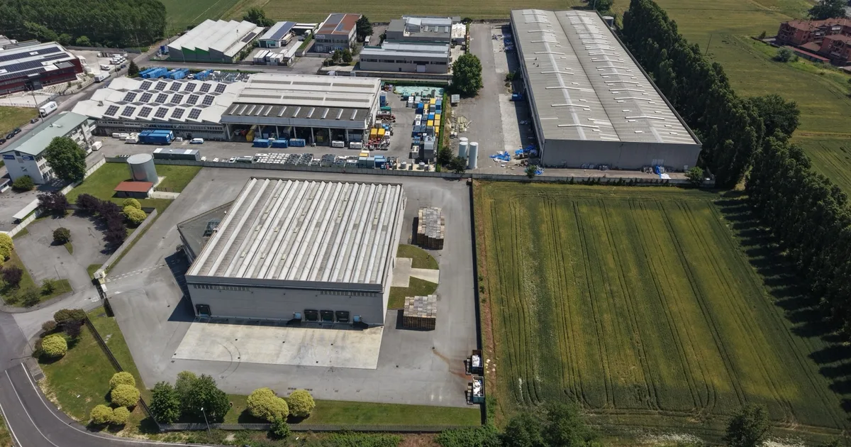 Aerial view of industrial warehouses with rooftop solar panels.